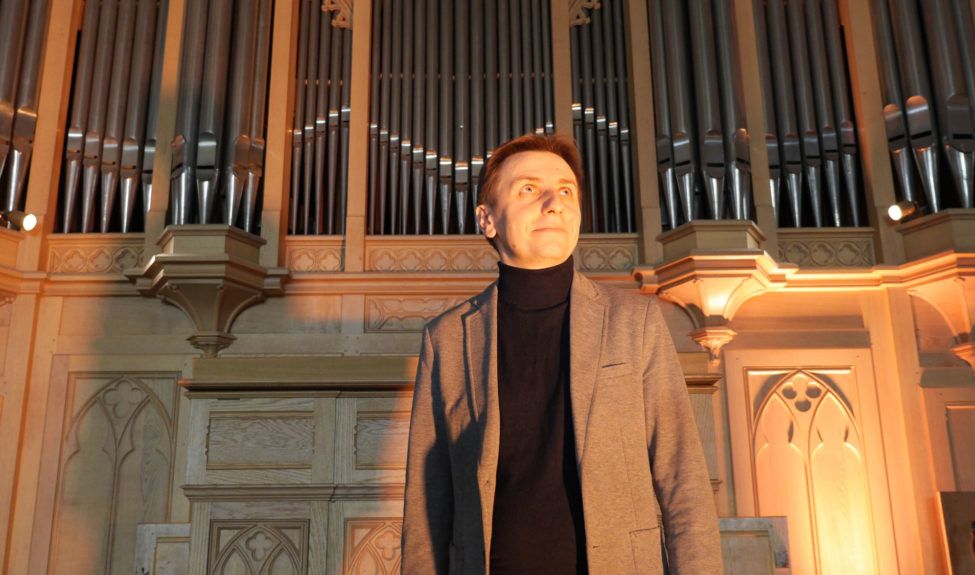 Portrait de Thomas Lacôte devant l'orgue Cavaillé-Coll