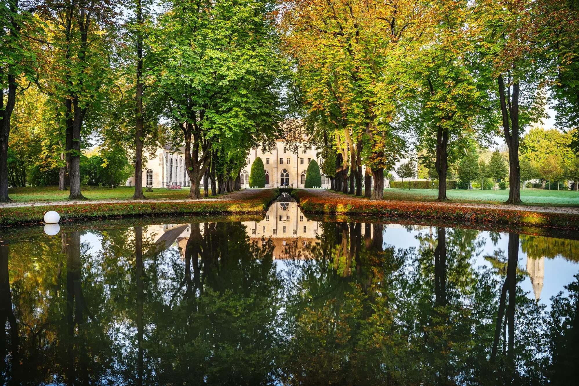 Paysage de l'abbaye de Royaumont avec une vue sur le point d'eau.